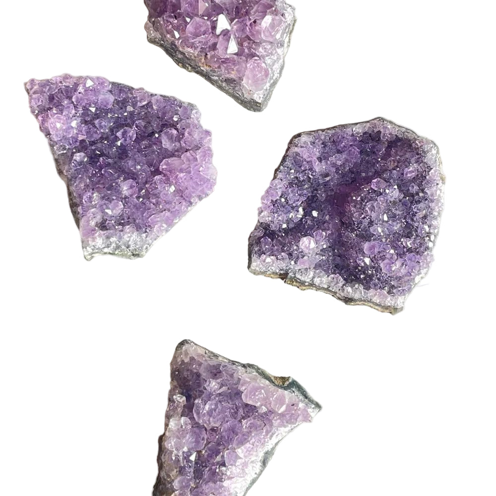 Several amethyst druses displayed on a marble surface, with their purple crystals visible.