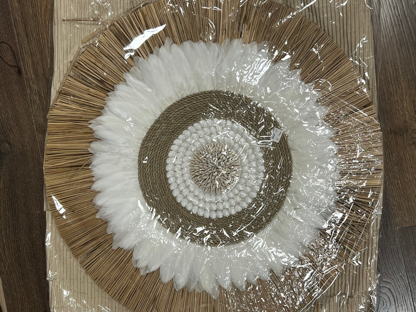 Round wall hanging with cowry, feather & grass