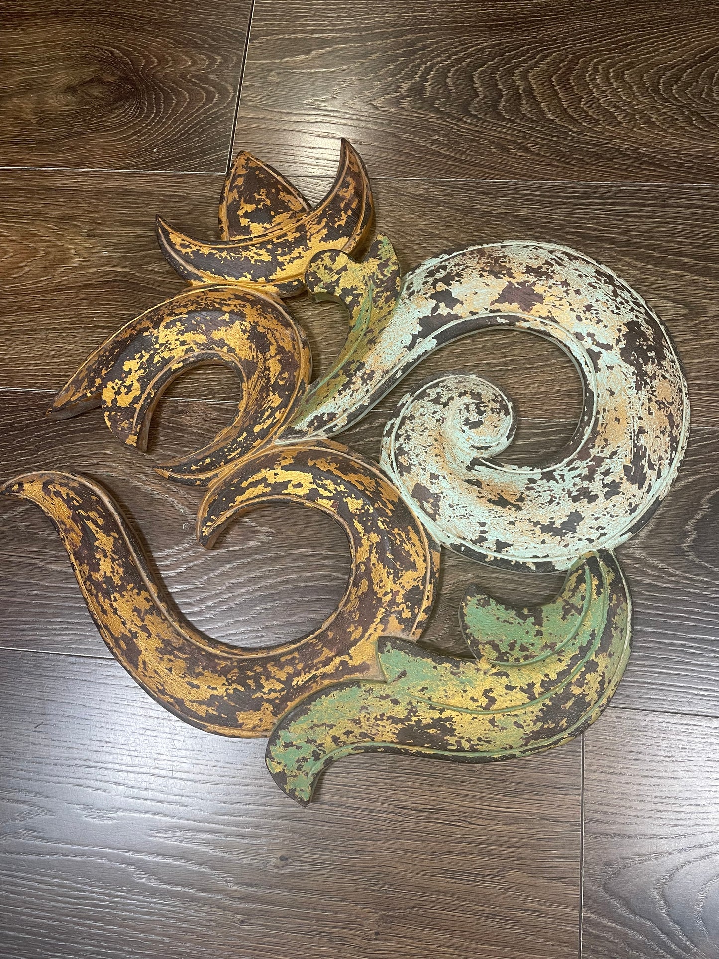 Decorative metal piece with swirling design on a wooden surface