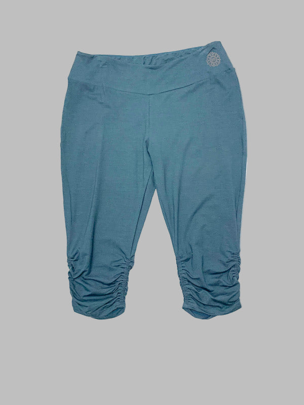 Cropped bamboo fabric leggings in a solid blue color with a gather at the hem.