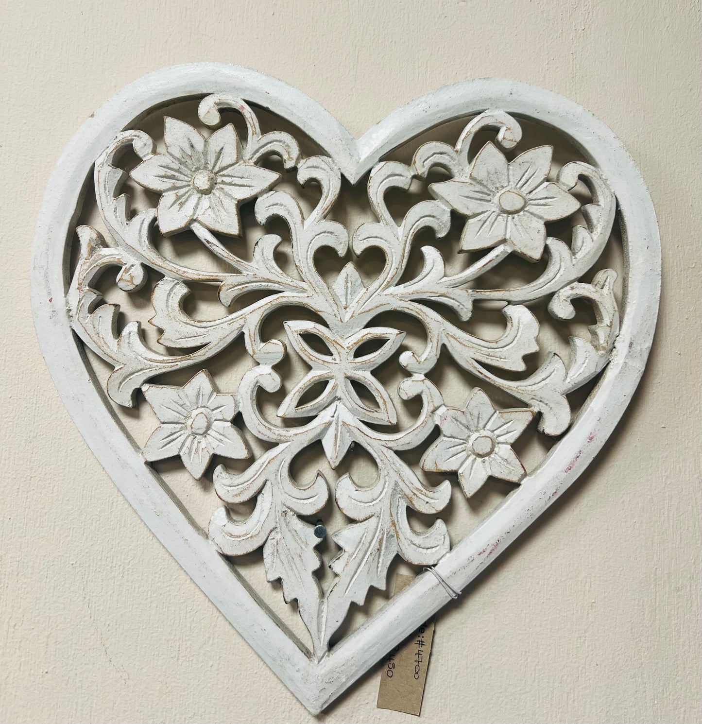 Decorative heart-shaped wall art with floral patterns on a beige background