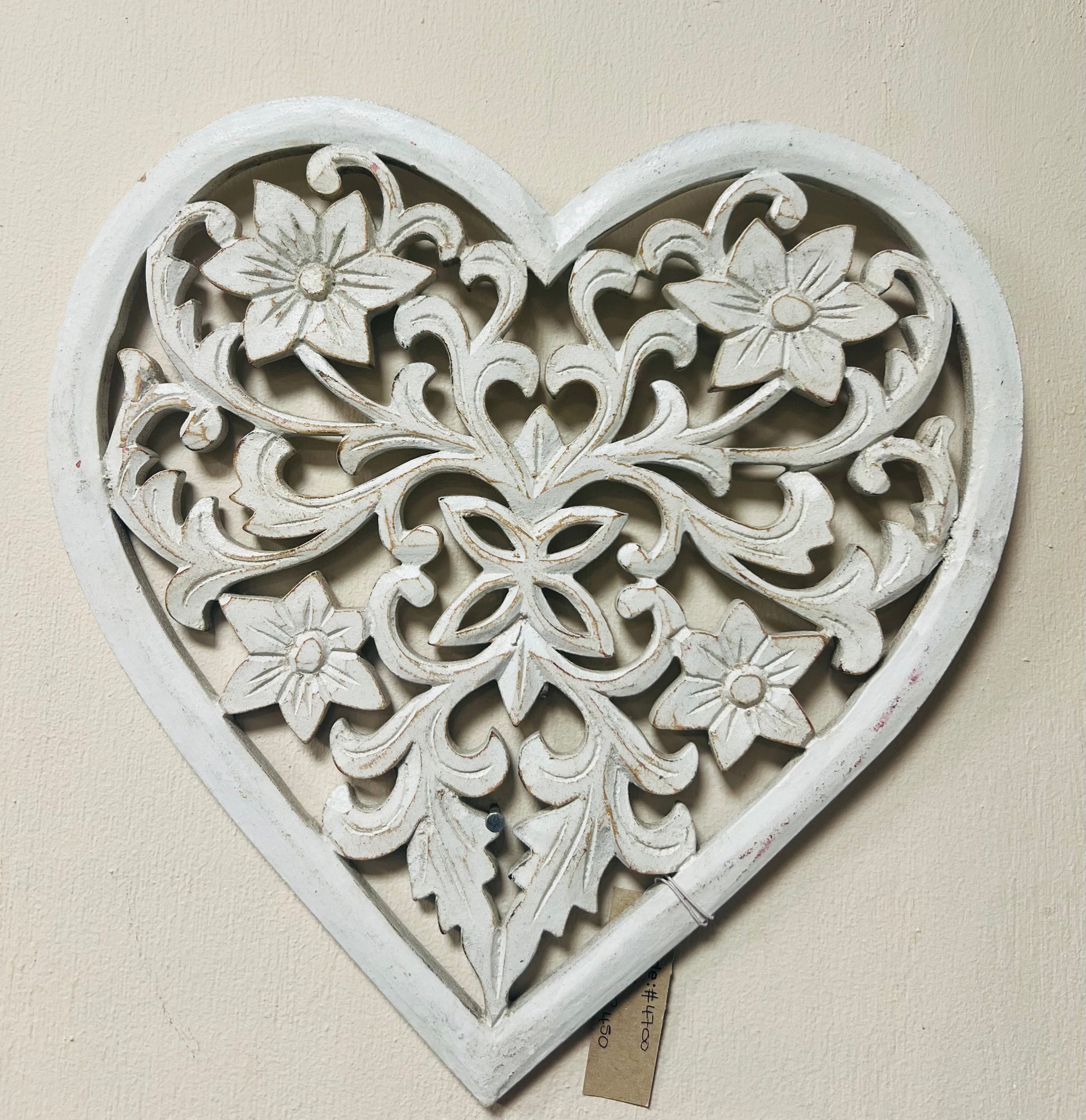 Decorative heart-shaped wall art with floral patterns on a beige background