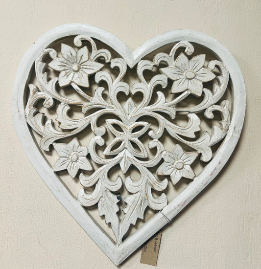 Decorative heart-shaped wall art with floral patterns on a beige background