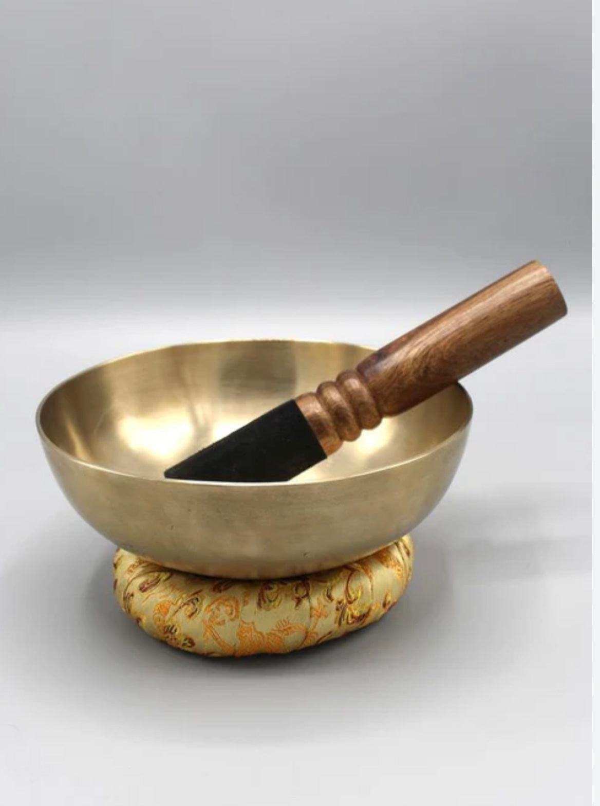 Brass bowl with wooden handle on a white background