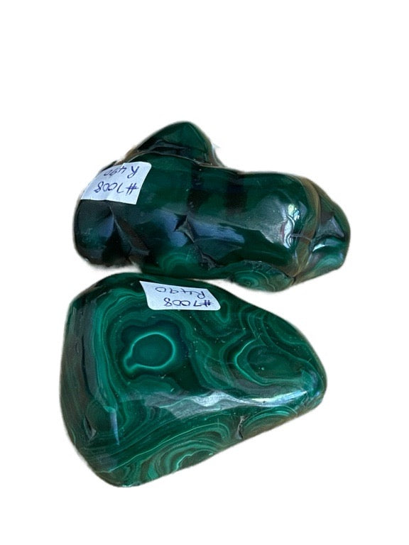 Two green malachite stones with labels on a white background