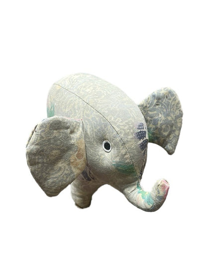 Plush elephant toy with a patterned design on a white background