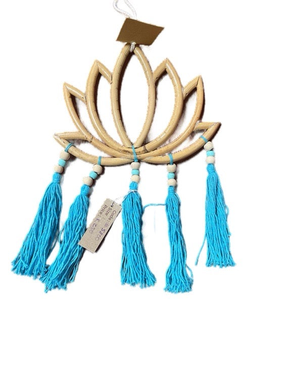 Decorative wall hanging with lotus design and blue tassels on a white background