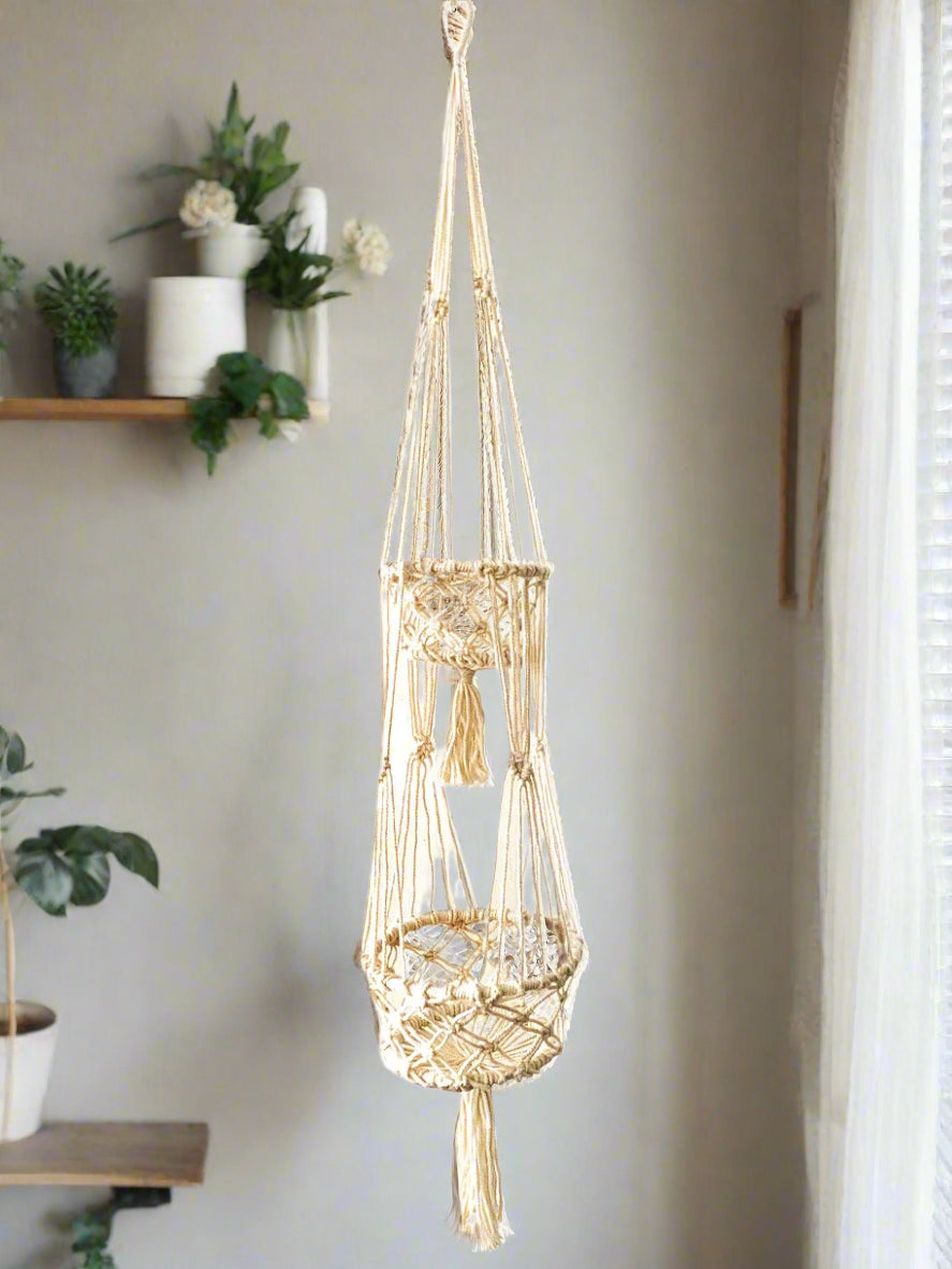 A bespoke handwoven macrame two-tier natural rope plant hanger, featuring two round wooden beaded baskets with sturdy hanging rope.